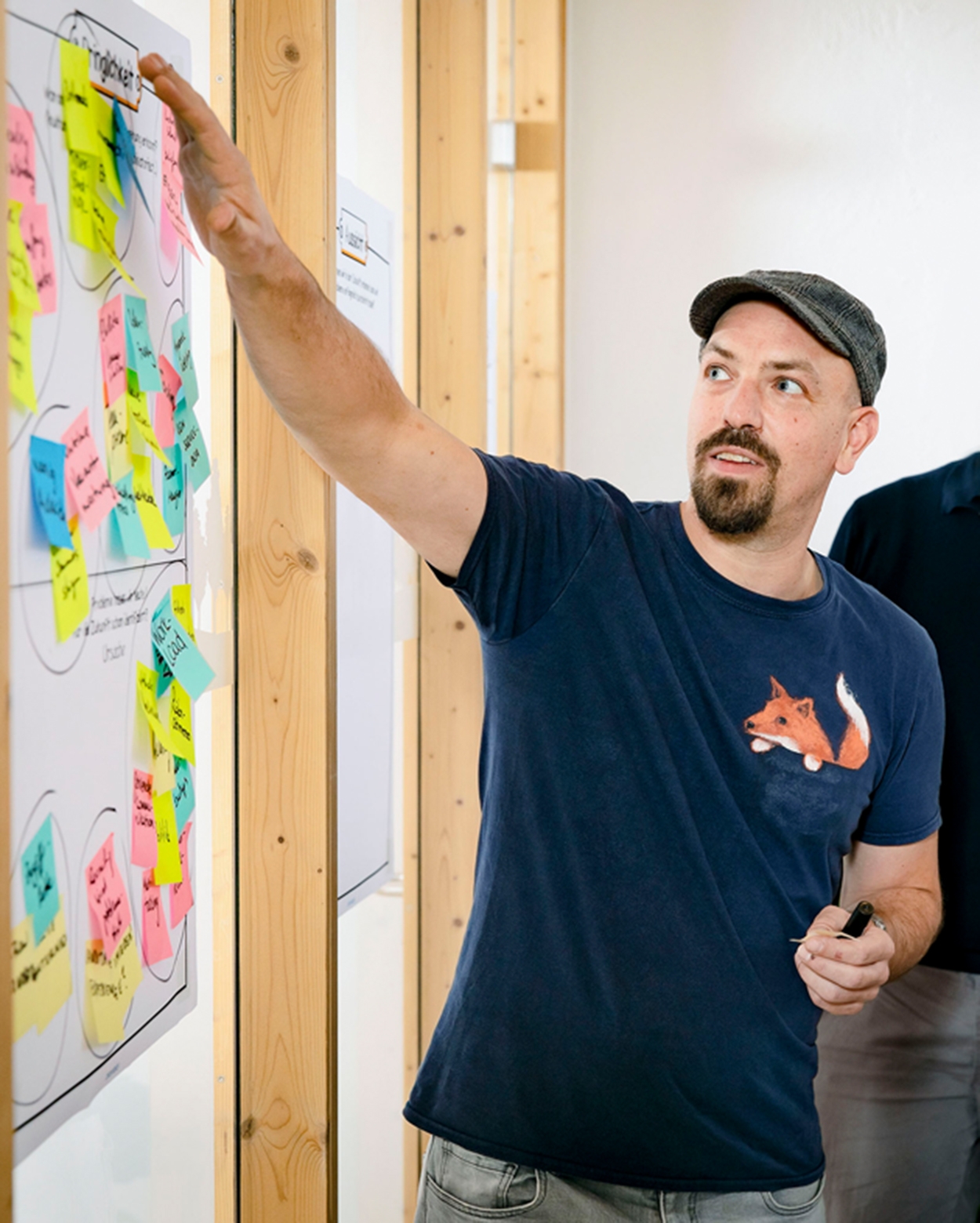 Ein Projektmanager und eine Entwicklerin unterhalten sich und schauen dabei auf einen Bildschirm