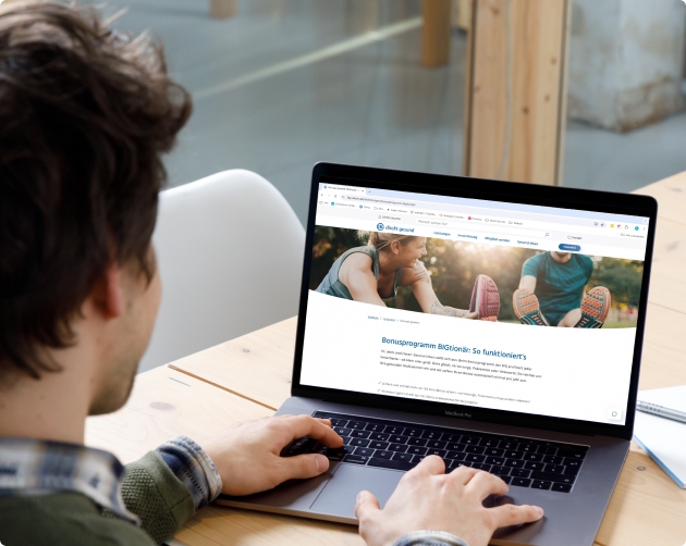 Ein Projektmanager und eine Entwicklerin unterhalten sich und schauen dabei auf einen Bildschirm